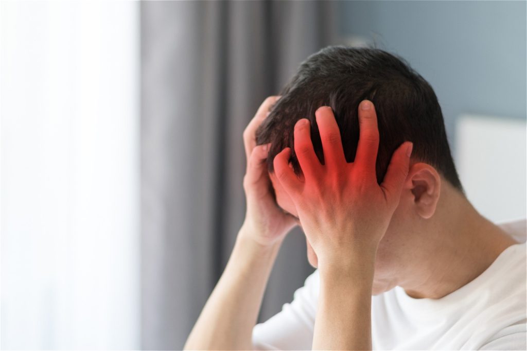 Person holding head in pain