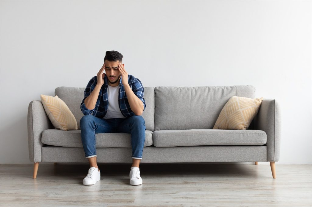 Man sitting on sofa stressed